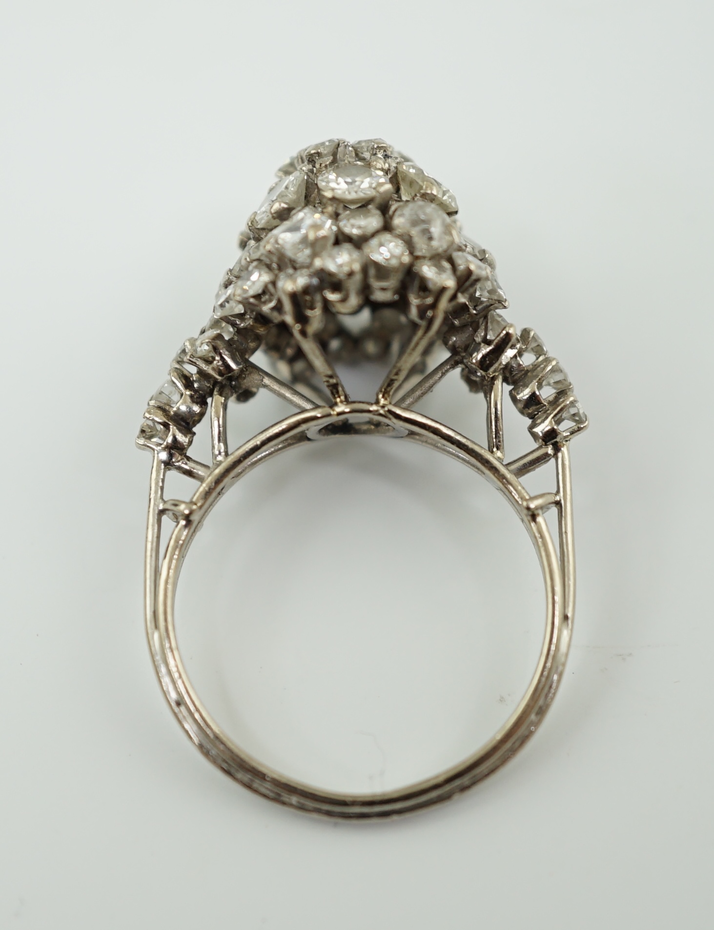 A mid 20th century platinum? and diamond cluster set dome shaped dress ring, with diamond set shoulders